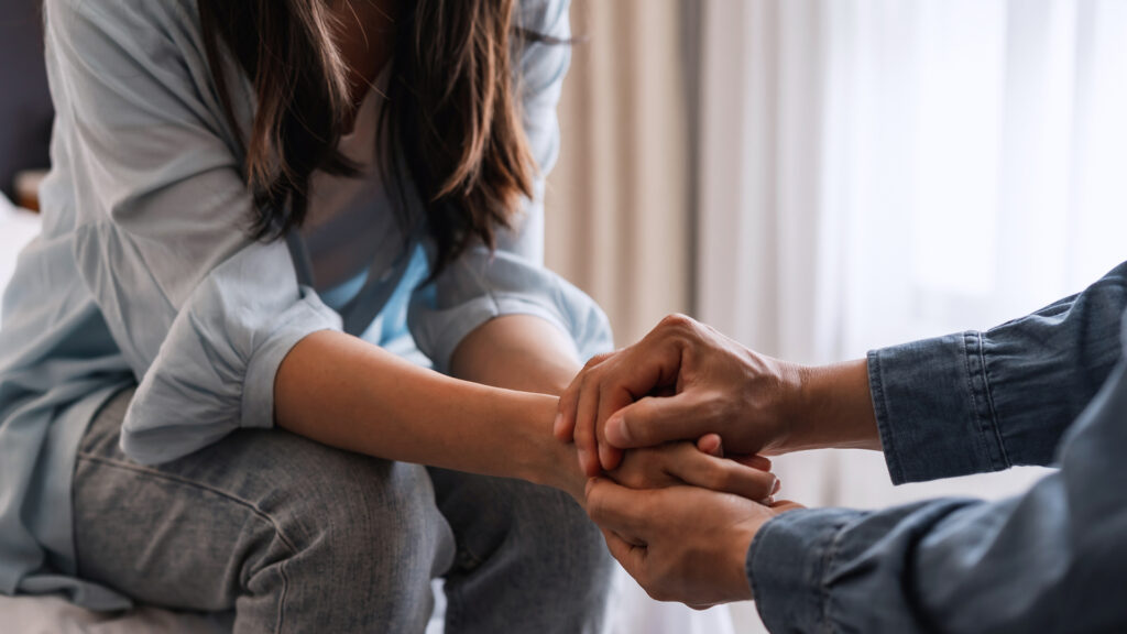 Young man comforting and supporting a sad woman who is in serious trouble at home, Consolation and encouragement concept