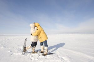 Two snowshoers kiss on the frozen snow on Great Slave Lake in Canada's Arctic. |