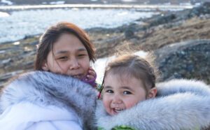 Inuit mother and daughter on Baffin Island, Nunavut, Canada.  Real people in traditional dress out on the tundra.